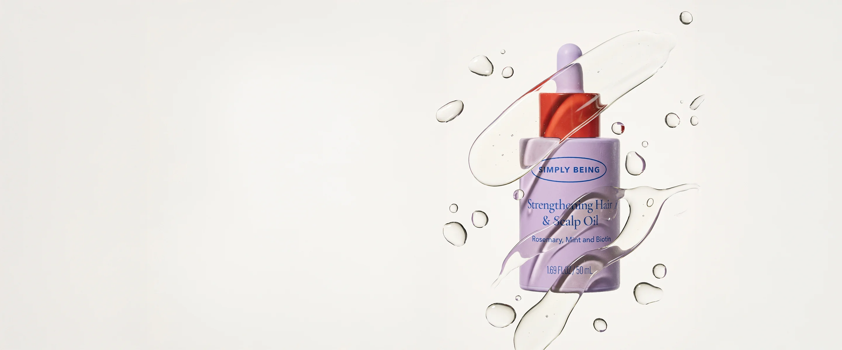 Strengthening Hair & Scalp Oil bottle with a swirl of clear oil and droplets